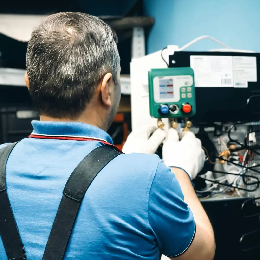 A skilled technician working on air conditioning system maintenance indoors.
